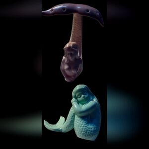 Ceramic mermaids, one blue and one pink, pink one is a jewelry holder.
